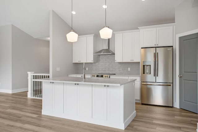 kitchen with stainless steel refrigerator with ice dispenser, light countertops, backsplash, a kitchen island with sink, and wall chimney exhaust hood