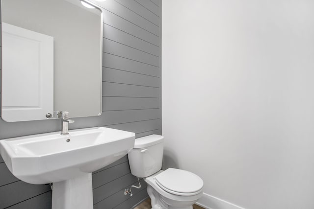 half bathroom with toilet and baseboards