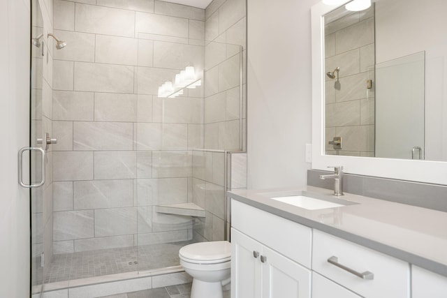 bathroom featuring vanity, a shower stall, and toilet