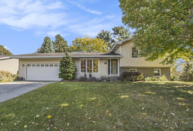 tri-level home with driveway, an attached garage, a front lawn, and brick siding