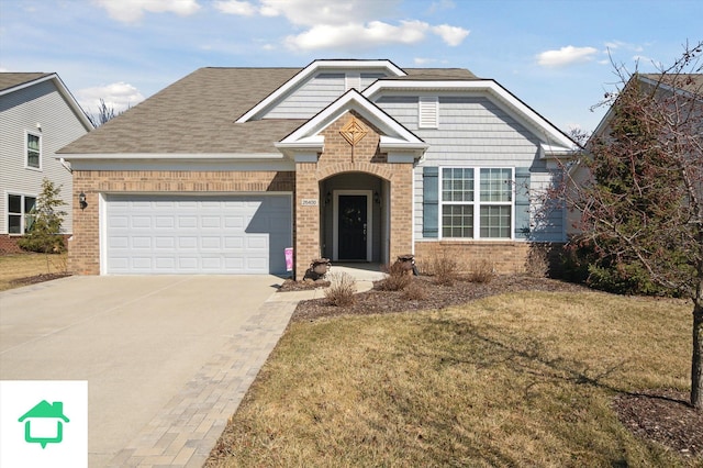 view of front of property featuring driveway, a shingled roof, a front lawn, a garage, and brick siding