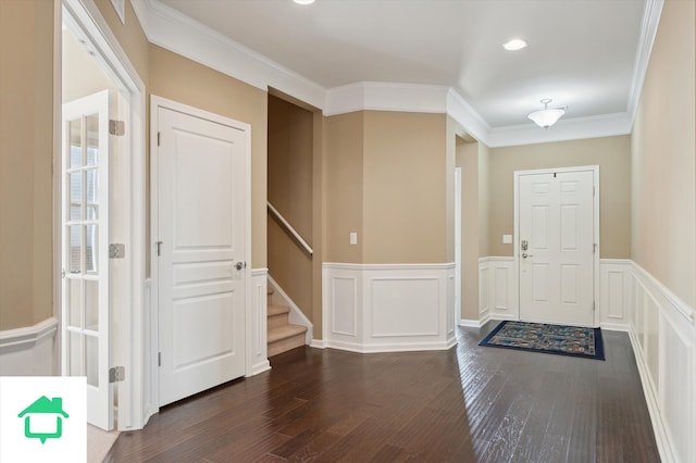 entryway featuring dark wood-style floors, a wainscoted wall, stairs, and ornamental molding