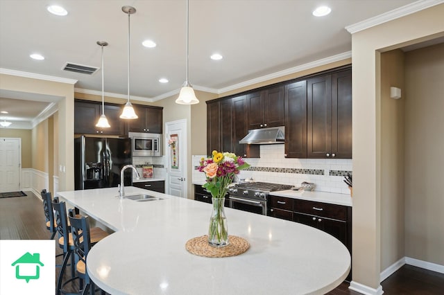 kitchen with visible vents, under cabinet range hood, a sink, stainless steel appliances, and dark brown cabinetry