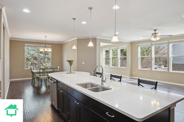 kitchen featuring dark wood-style floors, ornamental molding, light countertops, and a sink