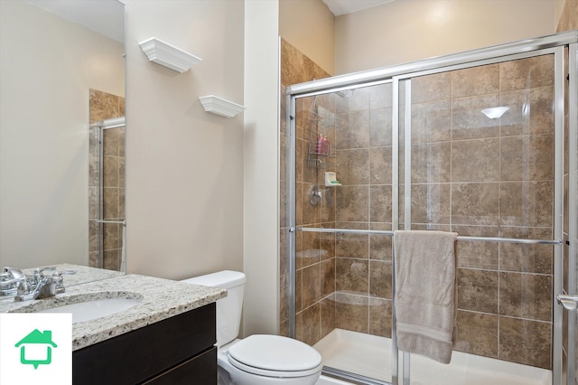 bathroom with vanity, toilet, and a stall shower