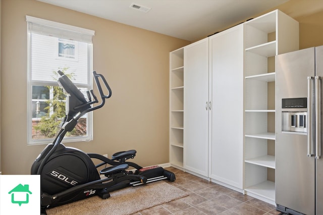 workout area featuring tile patterned flooring, a healthy amount of sunlight, and visible vents