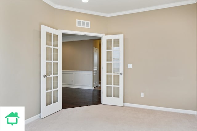 carpeted spare room featuring baseboards, french doors, visible vents, and ornamental molding