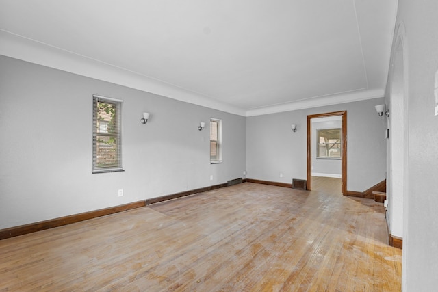 empty room featuring visible vents, baseboards, and light wood-style floors