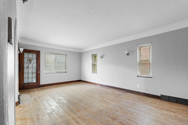 empty room with visible vents, baseboards, and wood finished floors