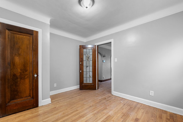 unfurnished room with baseboards and light wood-style flooring