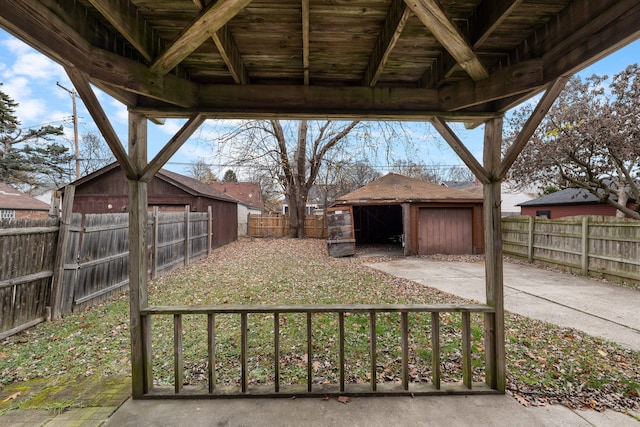 view of yard featuring a detached garage, an outbuilding, and a fenced backyard