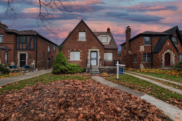 view of front facade with brick siding and a chimney