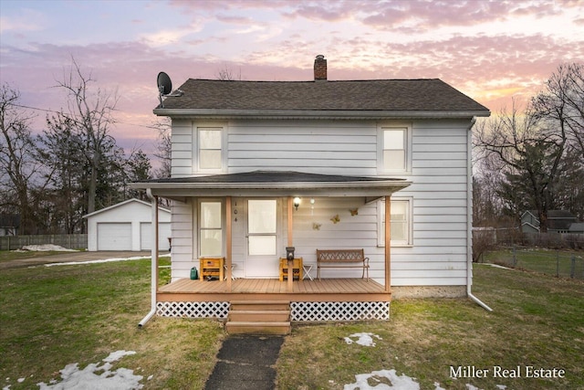 view of front of home with an outbuilding, a yard, a chimney, fence, and a garage