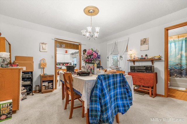 dining area featuring carpet, a notable chandelier, and baseboards