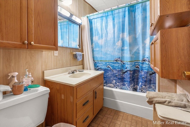 bathroom with brick floor, toilet, shower / bath combo, wood walls, and vanity