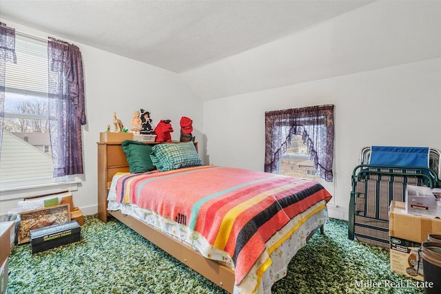 bedroom featuring vaulted ceiling and a textured ceiling