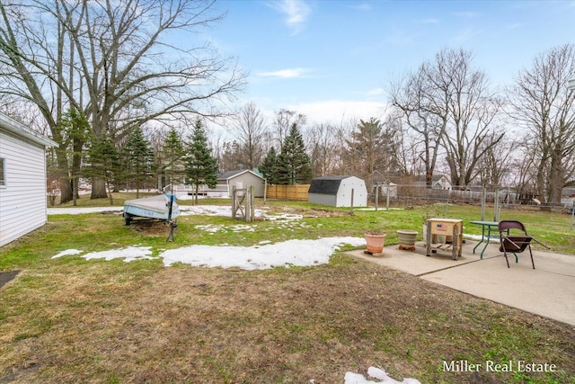 view of yard featuring a patio area, a shed, fence, and an outdoor structure