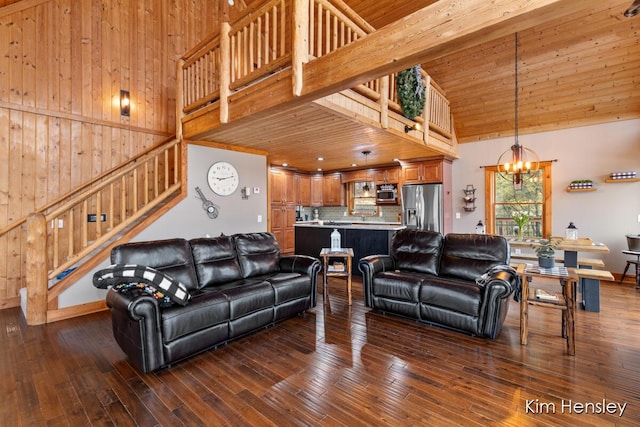 living area featuring an inviting chandelier, a high ceiling, stairway, and dark wood-style floors