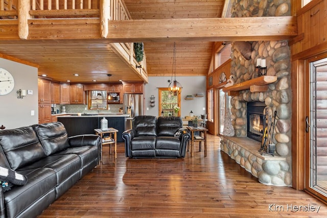 living area featuring dark wood finished floors, wood ceiling, a stone fireplace, high vaulted ceiling, and beam ceiling