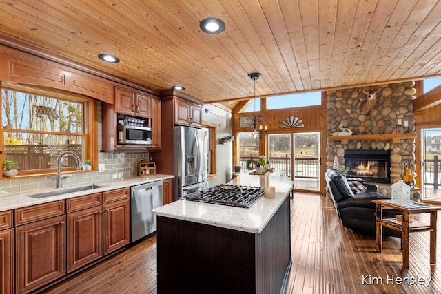 kitchen with decorative backsplash, wooden ceiling, stainless steel appliances, a fireplace, and a sink