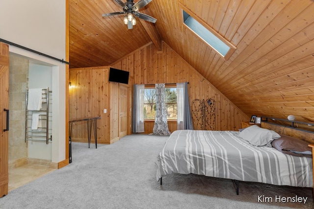 bedroom with vaulted ceiling with skylight, wood walls, carpet floors, and wood ceiling