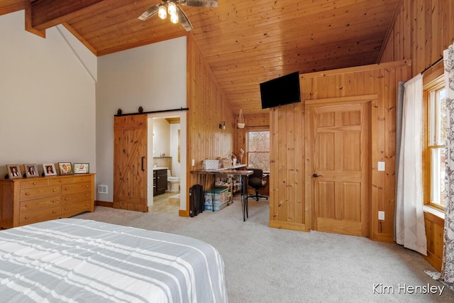 bedroom featuring a barn door, carpet flooring, wooden walls, and multiple windows