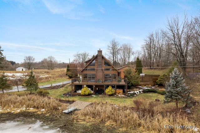 back of property with a chimney, fence, and a deck