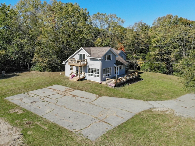 view of front facade featuring driveway, a front yard, and a wooden deck