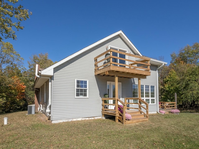 rear view of property with cooling unit, a yard, and a wooden deck