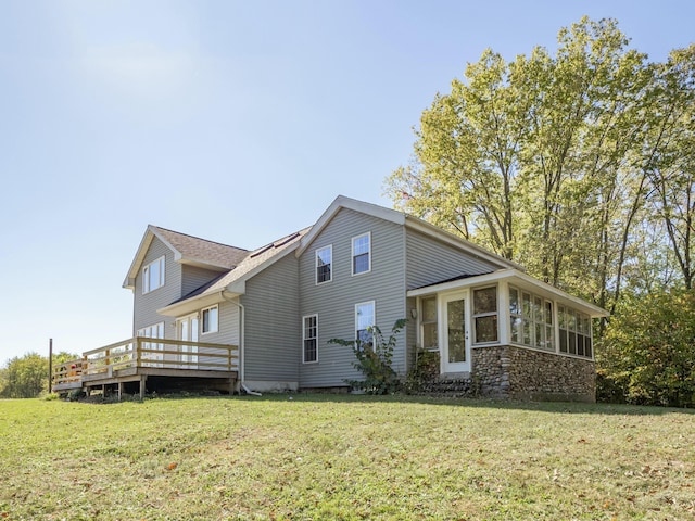 view of side of home with a sunroom, a deck, and a lawn