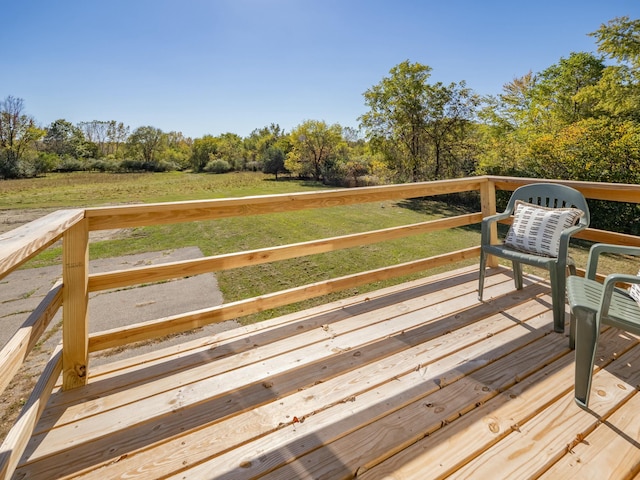 wooden deck with a lawn and a forest view