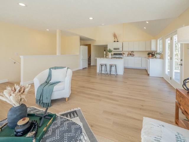 living room featuring light wood-type flooring, lofted ceiling, and recessed lighting