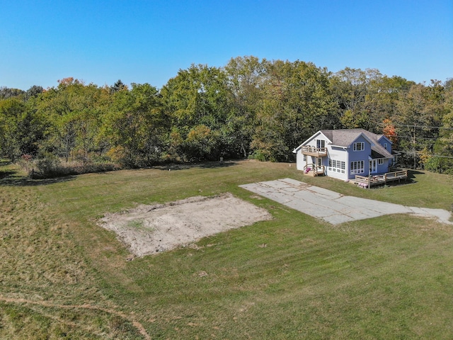 view of yard with driveway and a forest view