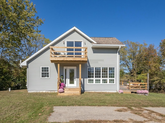 exterior space featuring a shingled roof, a yard, and a balcony