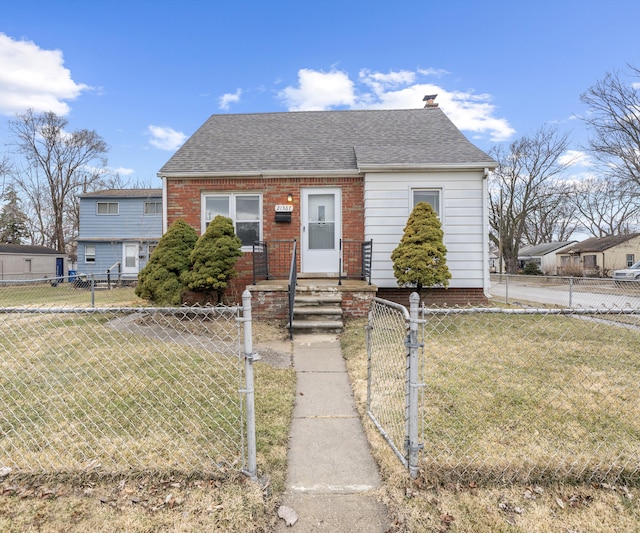 bungalow-style house featuring a fenced front yard, a front yard, a gate, and roof with shingles