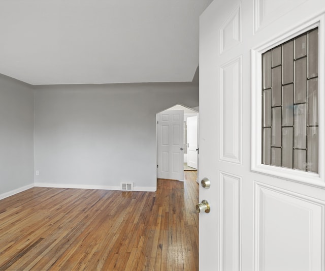 interior space featuring baseboards, visible vents, and hardwood / wood-style floors