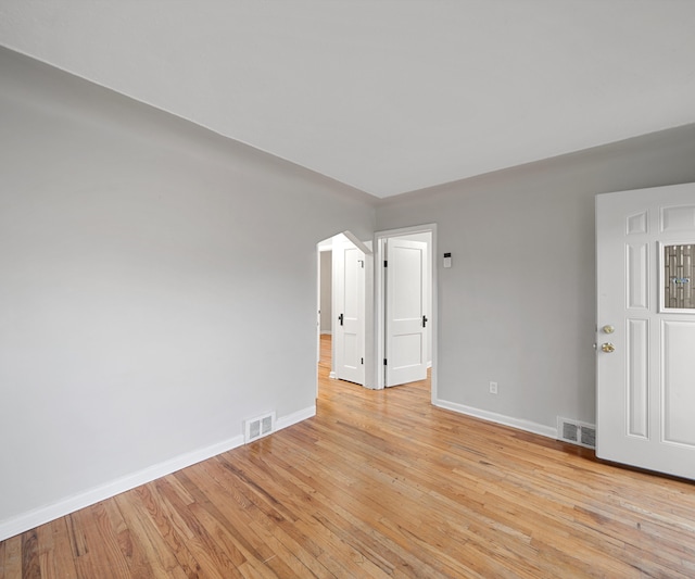 spare room featuring light wood-style floors, baseboards, and visible vents