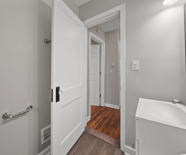 bathroom with vanity, wood finished floors, visible vents, and baseboards