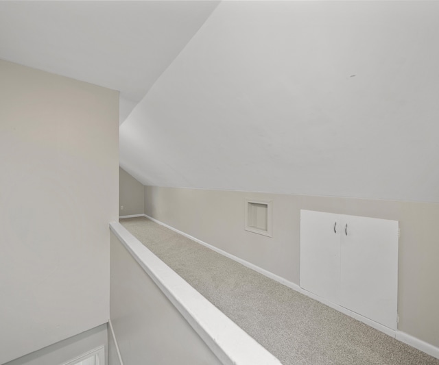 interior space with lofted ceiling, carpet, and baseboards