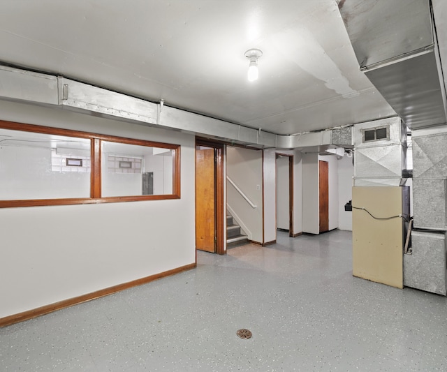 finished basement featuring visible vents, stairway, and baseboards