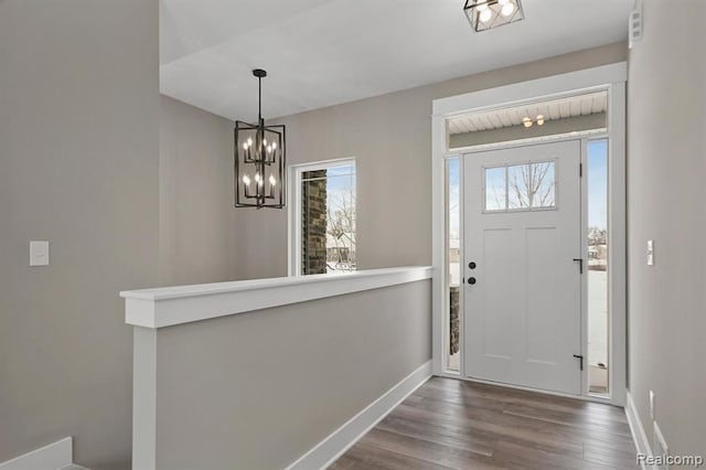 entrance foyer with baseboards, dark wood-style floors, and a notable chandelier