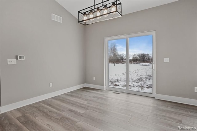 unfurnished dining area featuring visible vents, baseboards, and wood finished floors