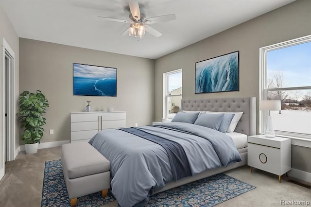 bedroom with light carpet, ceiling fan, and baseboards