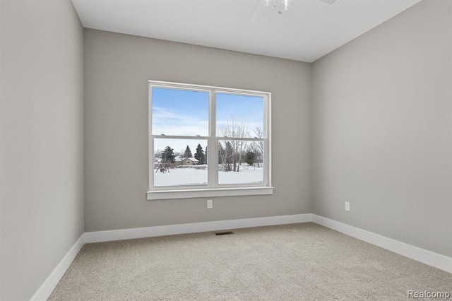 unfurnished room featuring healthy amount of natural light, carpet, baseboards, and ceiling fan