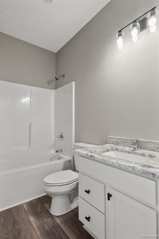 full bathroom featuring washtub / shower combination, vanity, toilet, and wood finished floors