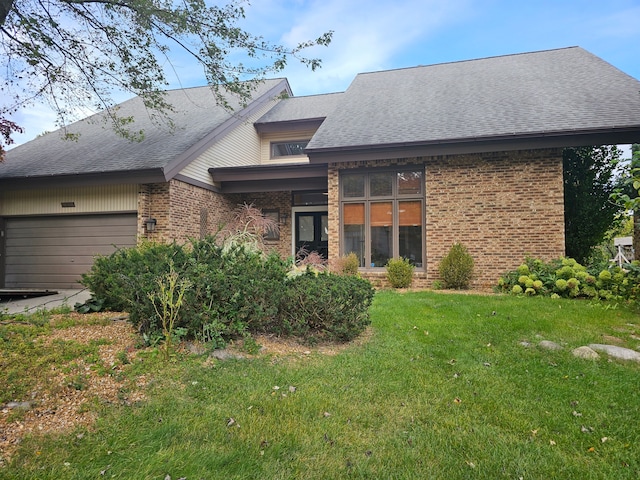 exterior space featuring brick siding, a garage, a yard, and roof with shingles