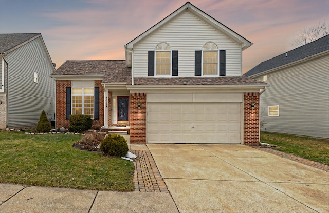 traditional-style house with brick siding, a garage, driveway, and a front lawn