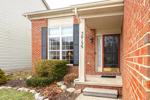 view of exterior entry with brick siding