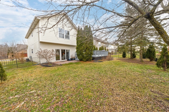 back of house featuring a deck, a lawn, a patio, and a fenced backyard