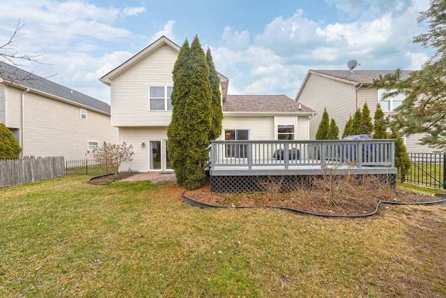 rear view of property featuring a fenced backyard, a deck, and a yard